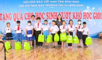 Đồng chí Lê Bình Thanh - Tỉnh ủy viên, Bí thư Huyện ủy và Nhà báo Huỳnh Thúc Giáp - Thư ký Chi hội Nhà báo thường trú tại Bình Định trao tặng quà cho học sinh vượt khó học giỏi