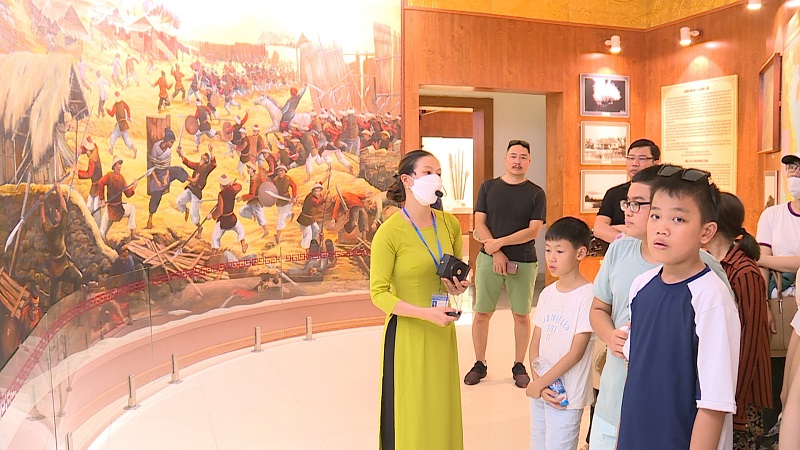 Du khách nghe hướng dẫn viên thuyết minh tại Bảo tàng Quang Trung giới thiệu về lịch sử nhà Tây Sơn