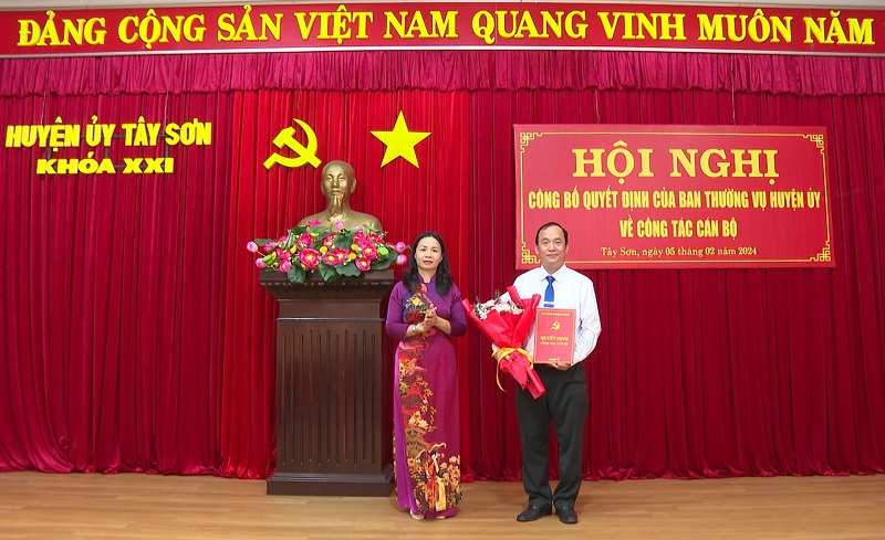 Đồng chí Lê Bình Thanh - Tỉnh ủy viên, Bí thư Huyện ủy Tây Sơn trao quyết định và tặng hoa chúc mừng đồng chí Trịnh Văn Lập